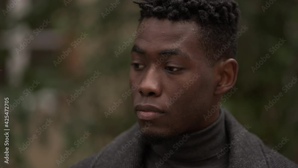 Contemplative young black man in meditative expression outside, close-up face Contemplative young black man in meditative expression outside, close-up face