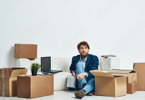 A man sits on the floor of a box with things office moving unpacking official © SHOTPRIME STUDIO