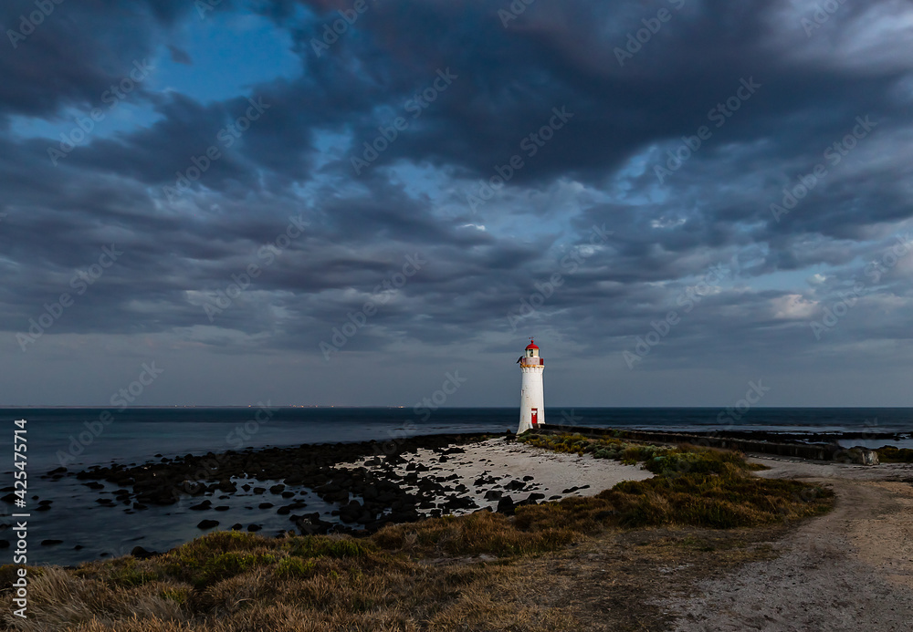Port Fairy Lighthouse over the ocean with dark clouds