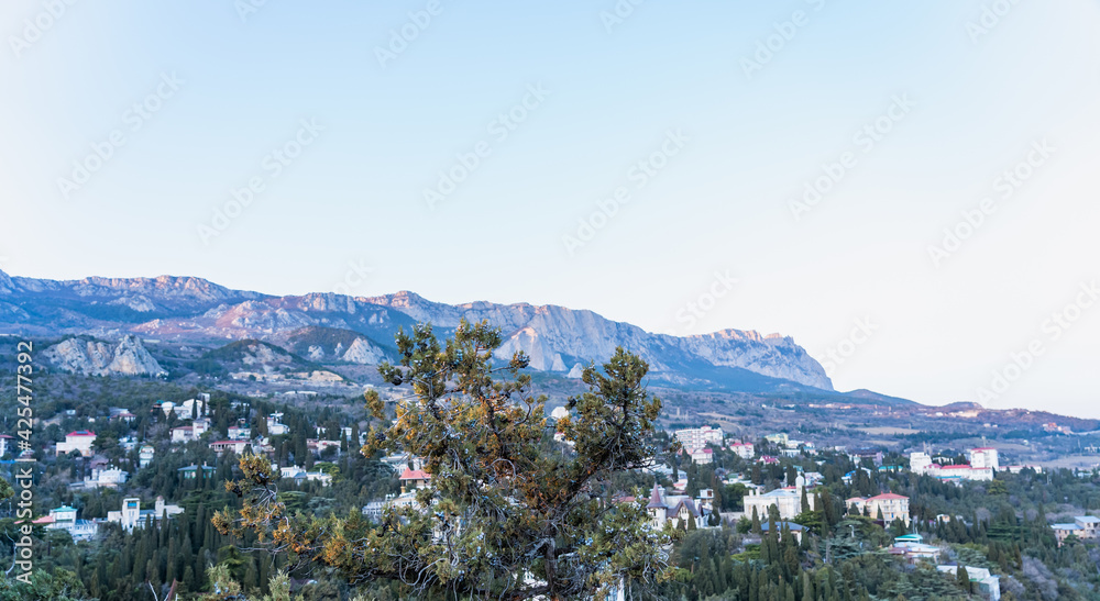 Sunrise in the mountains. Panoramic view of a small village next to the mountains