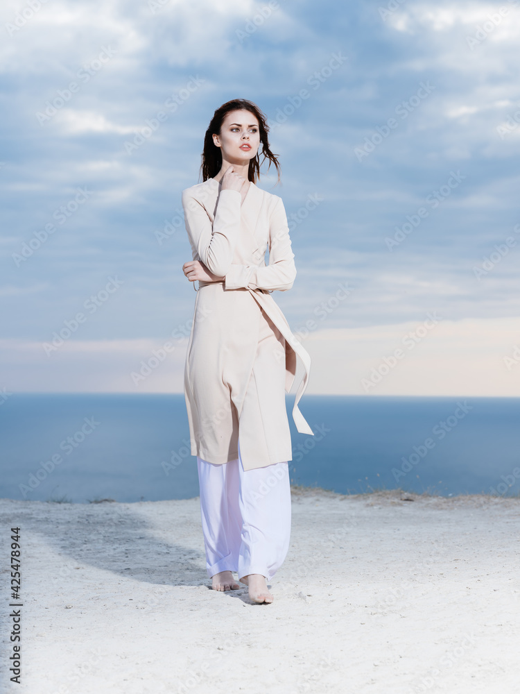woman in light clothes by the ocean and blue sky in the background woman in light clothes by the ocean and blue sky in the background