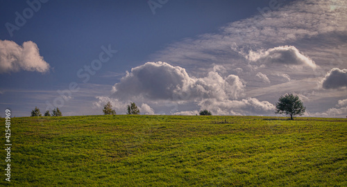 Small hill, green grass and beautiful sky photo