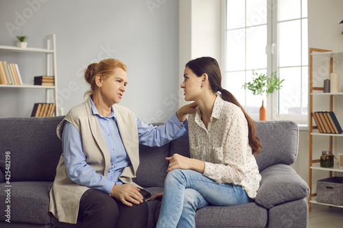 Cuadro en lienzo Senior mother and young grown-up daughter talking sitting on sofa at home