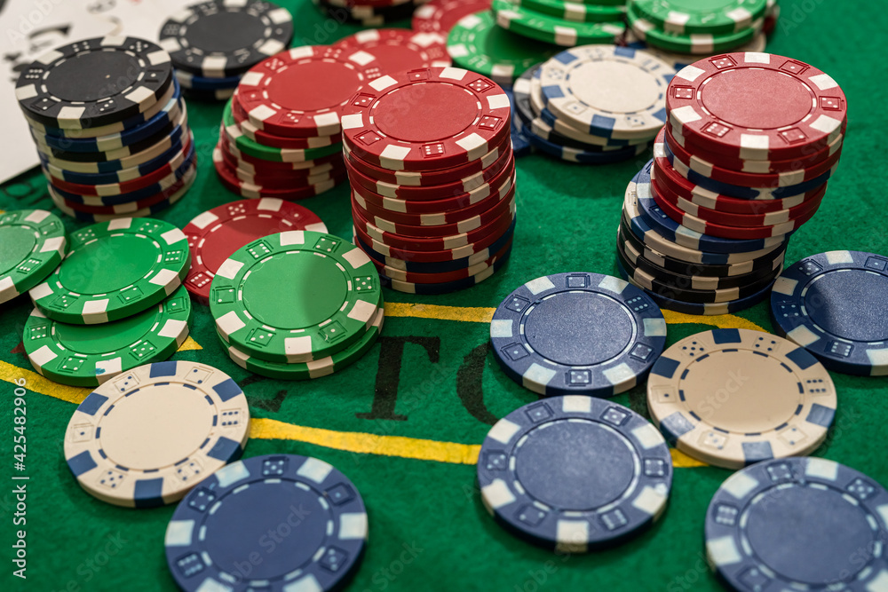 Gambling chips on green table in casino Gambling chips on green table in casino