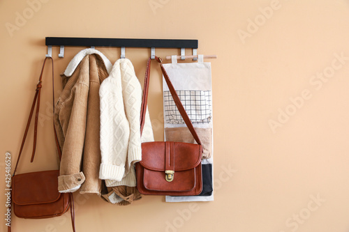 Stylish clothes hanging on wall in hall photo