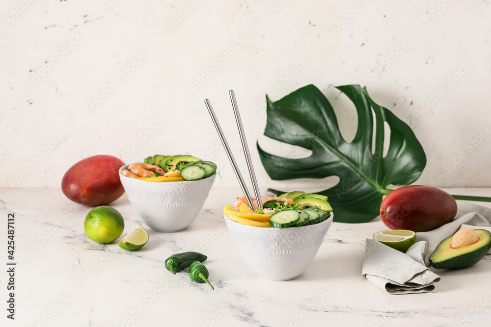Bowls of fresh salad with mango, shrimps and vegetables on light background - obrazy, fototapety, plakaty 