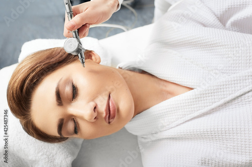 Jet peeling skin renewal procedure. Cropped woman s face with eye close while jet peel procedure