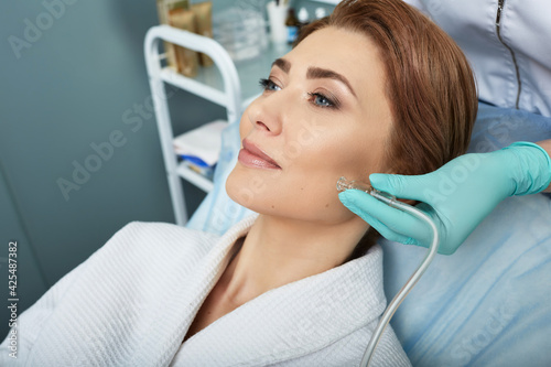 Fotografie Facial ozone therapy for woman's face rejuvenation at a beauty salon
