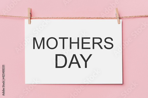 note letter pin on rope on pink background, love and valentine concept with text mothers Day