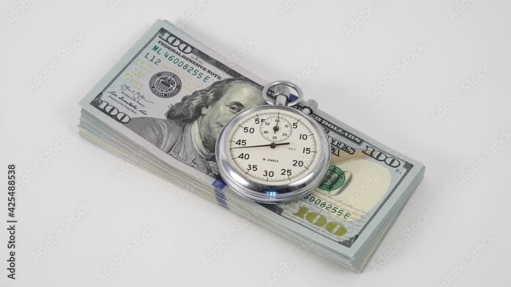 Stopwatch and dollars. Stopwatch lie on a paper banknotes. Cash. Money macro shot. Analogue metal stopwatch on the American dollar banknotes. Stopwatch lays on hundred dollar bills. Stopwatch and dollars. Stopwatch lie on a paper banknotes. Cash. Money macro shot. Analogue metal stopwatch on the American dollar banknotes. Stopwatch lays on hundred dollar bills.