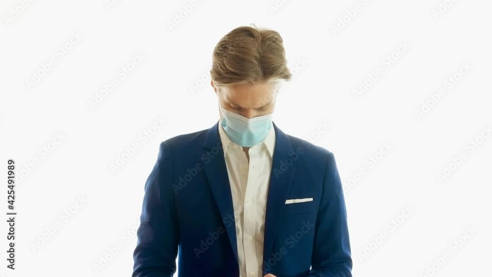 Young businessman with face mask isolated on white background. Using mobile phone browsing, typing sms message. Medium shot 4k Young businessman with face mask isolated on white background. Using mobile phone browsing, typing sms message. Medium shot 4k