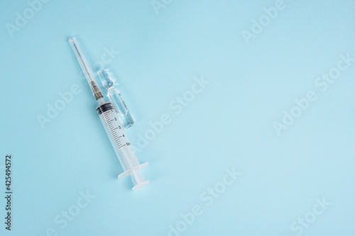 Syringe and ampoule on blue background