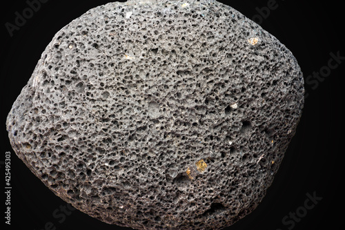 Porous volcanic rock isolated on black background, gray pumice stone texture for spa, exfoliation, skincare, and geological research, natural basalt mineral specimen
