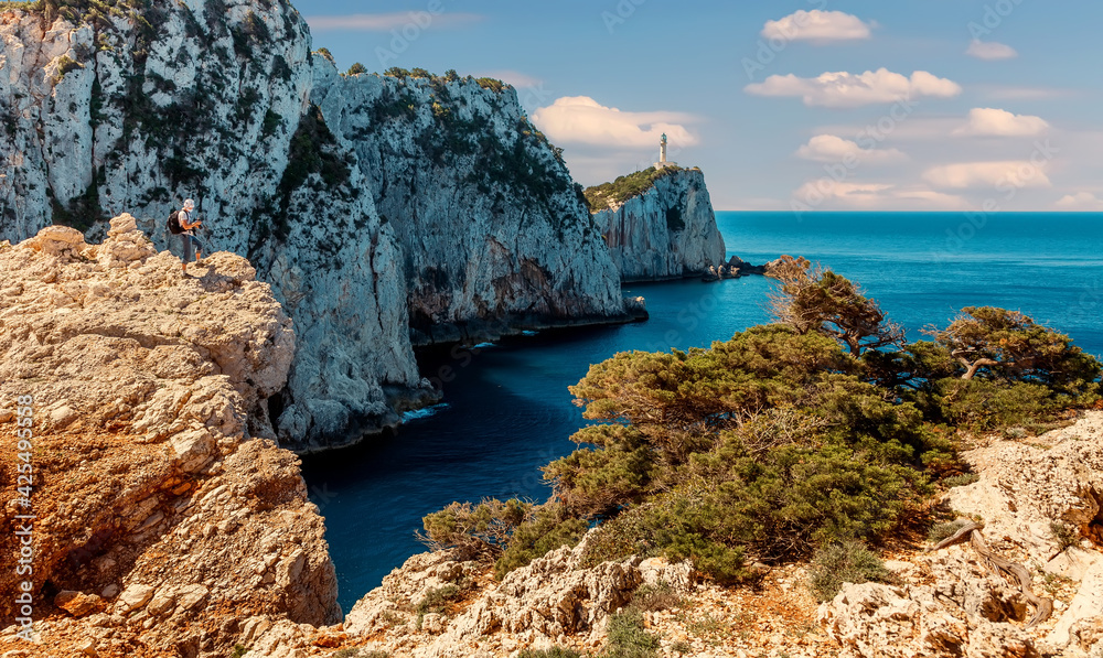 Wonderful View of the Lighthouse on the cliff. sunny seascape of Cape Lefkatas with old lighthouse in summer day. Stunning picturesque vivid landscape over the Ionian Sea. Lefkada island. Greece.