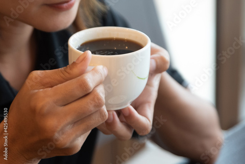 cropped shot of barista holding cup of aromatic coffee in hand