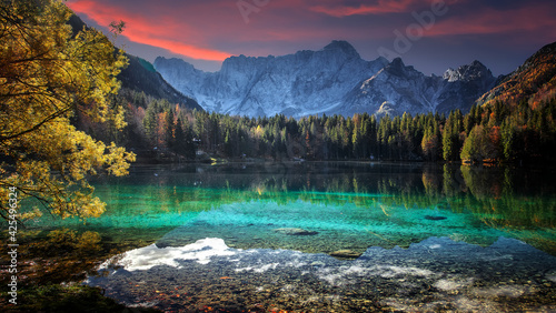 Fototapeta Naklejka Na Ścianę i Meble -  Fantastic Vivid nature landscape. Scenic image of Fusine lake during sunset. Popular travel and hiking destination. Picture of wild area. Awesome nature Background. Concept of an ideal resting place.