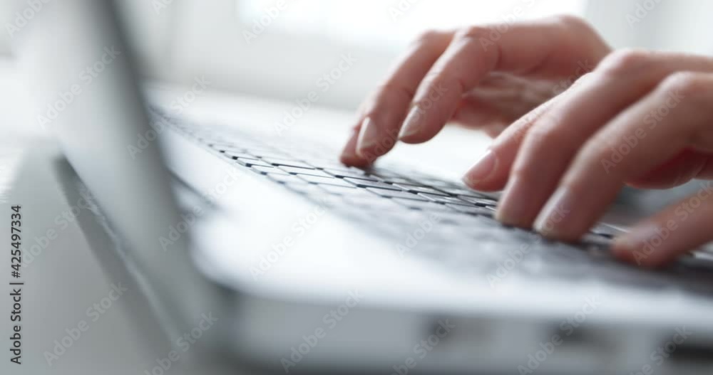 Cropped hands of a business woman typing text or working on a laptop keyboard. Close-up.