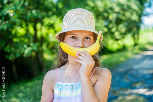 Banana smile. Funny baby on natural landscape. Teeth health. Tooth filling. Dental care. Oral hygiene. Healthy gums. Pediatric dentistry. Natural nutrition. Vitamin. Benefits of fruit. Reason to smil