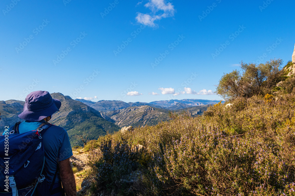 Hikers walking on mountains, in a sunny spring day. In La vall de laguar, Alicante (Spain)