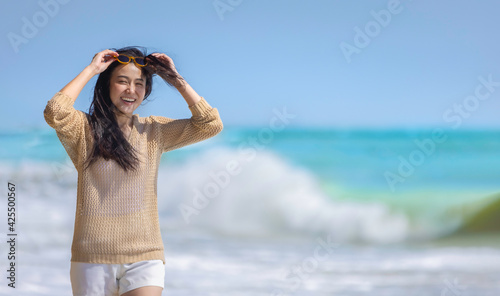 Freedom life wellness summer concept, Carefree Asian happy female with sunglasses enjoy walking on the beach wiht beautiful blue sea