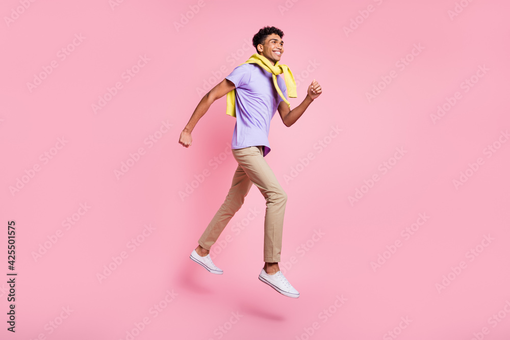 Full size profile side photo of young handsome cheerful smiling afro man running in air isolated on pink color background
