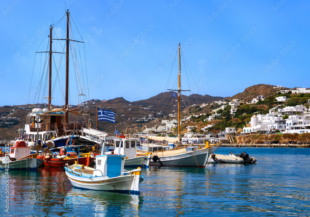 Beautiful summer day in marina of Greek island. Colorful fishing boats. Whitewashed houses. Mykonos, Cyclades, Greece.