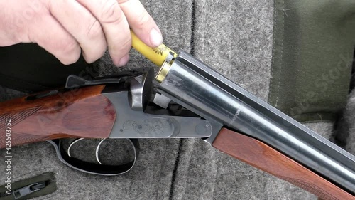 Loading the gun with bullets. The shooter is preparing for the hunt.