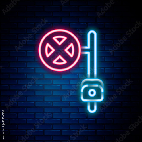 Glowing neon line Stop sign with camera icon isolated on brick wall background. Traffic regulatory warning stop symbol. Colorful outline concept. Vector