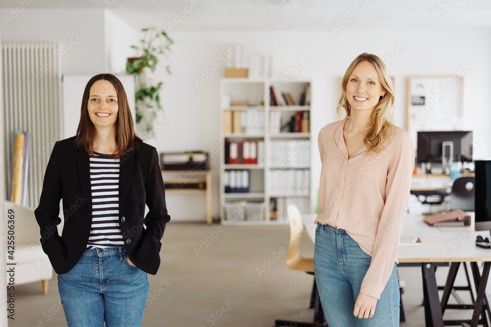 Two happy successful business colleagues or partners in a spacious office - obrazy, fototapety, plakaty 