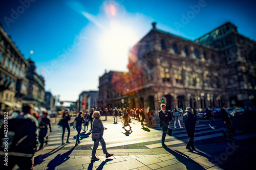 Crowd of anonymous people walking on busy city street