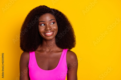 Photo of young attractive black girl happy positive smile dream dreamy look empty space isolated over yellow color background