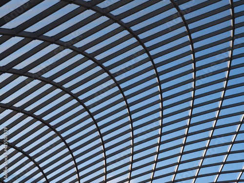 Glass roof with metal construction against blue sky on a sunny day