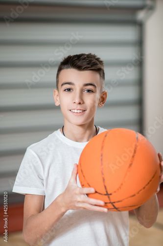 A cute boy with a ball looking contented © zinkevych
