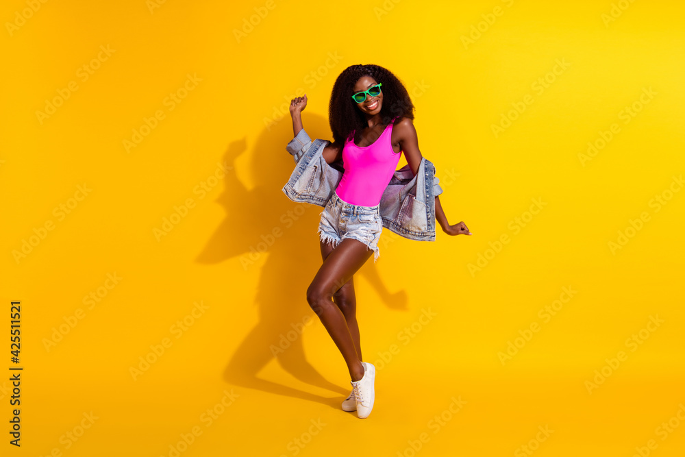 Full length photo of afro american stunning girl dance wear sunglass isolated on yellow color background