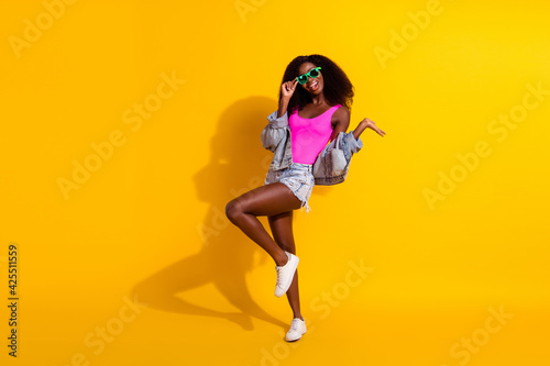 Full length photo of brunette pretty afro american lady dance summer mood isolated on yellow color background