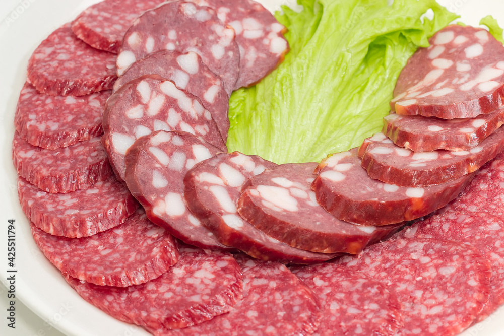 Sliced dry-cured and smoked sausages, closeup in selective focus Sliced dry-cured and smoked sausages, closeup in selective focus