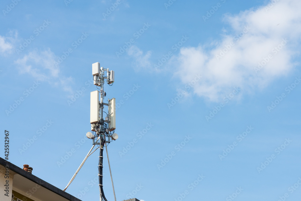 5g and 4g antenna on the roof of a residential building, Milan, Italy. Blue sky on the background