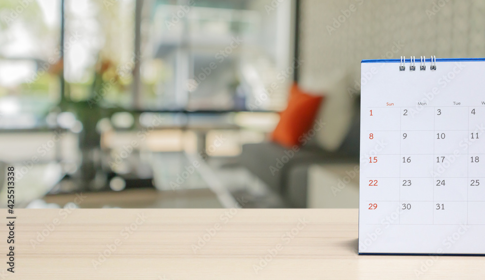 white paper desk calendar on wood table with blurred bokeh background appointment and business meeting concept white paper desk calendar on wood table with blurred bokeh background appointment and business meeting concept