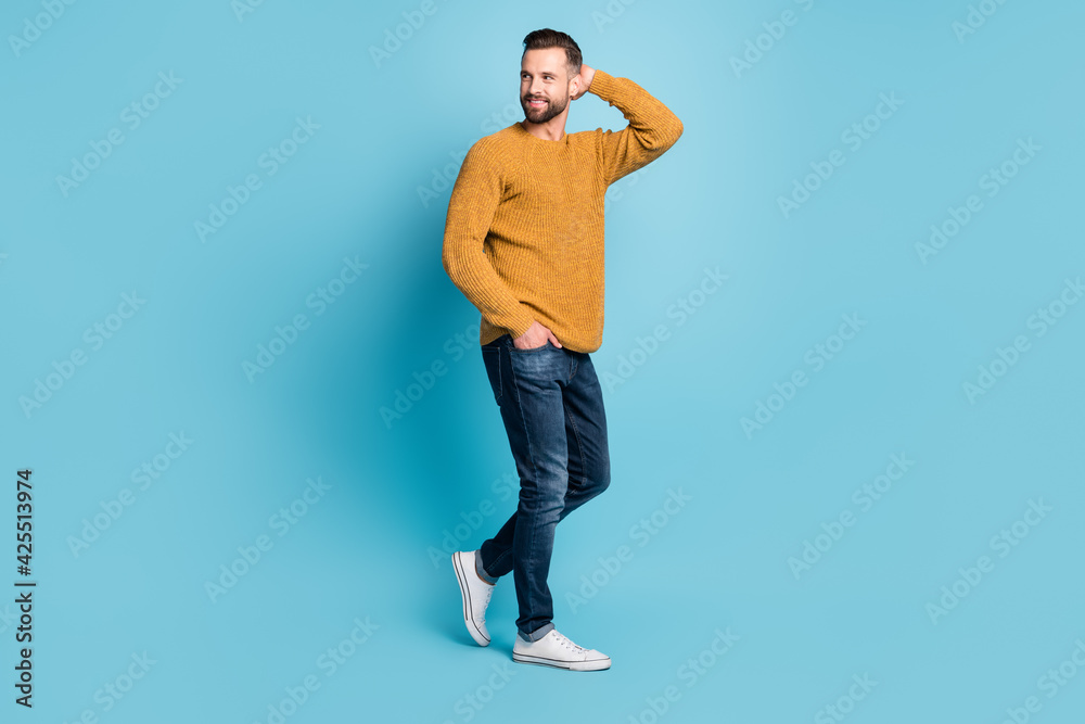 Full size photo of young handsome attractive smiling man look copyspace wear jeans isolated on blue color background