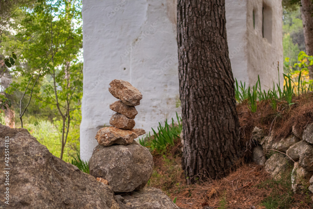 Fototapeta premium Stones stacked in the shape of a landmark, in a forest.