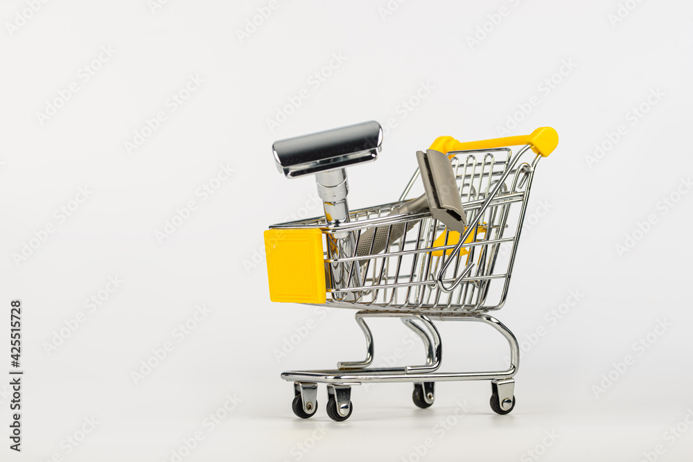 metallic safety razors in shopping cart isolated on white background 