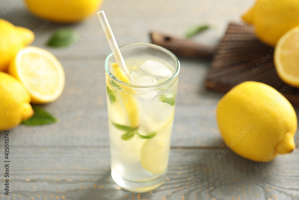 Fototapeta premium Cool freshly made lemonade and fruits on grey wooden table, closeup