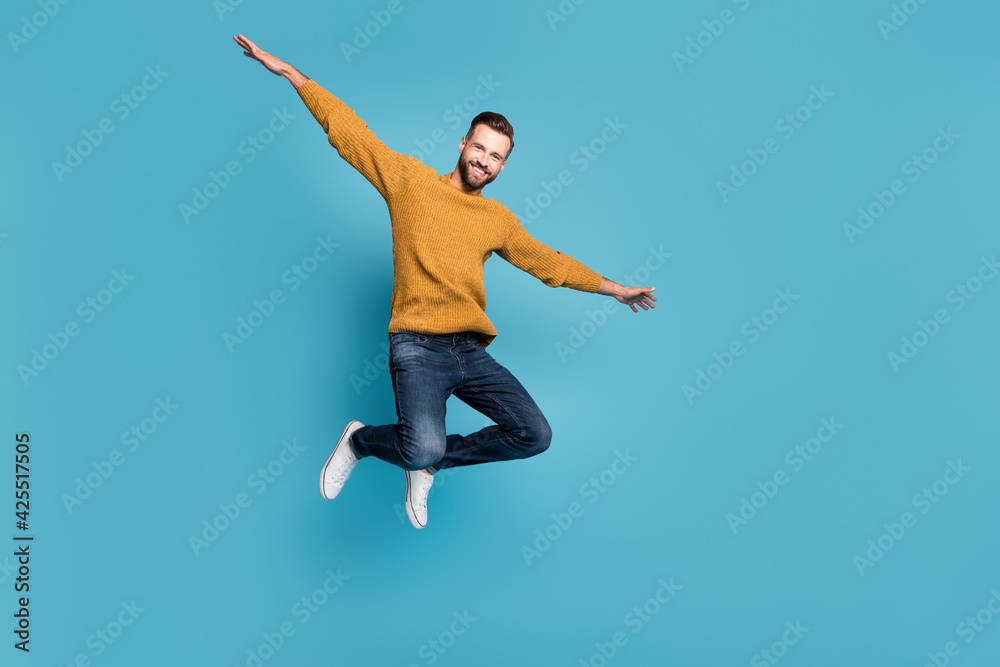Full length body size view of attractive cheerful guy jumping having fun like plane isolated on bright blue color background