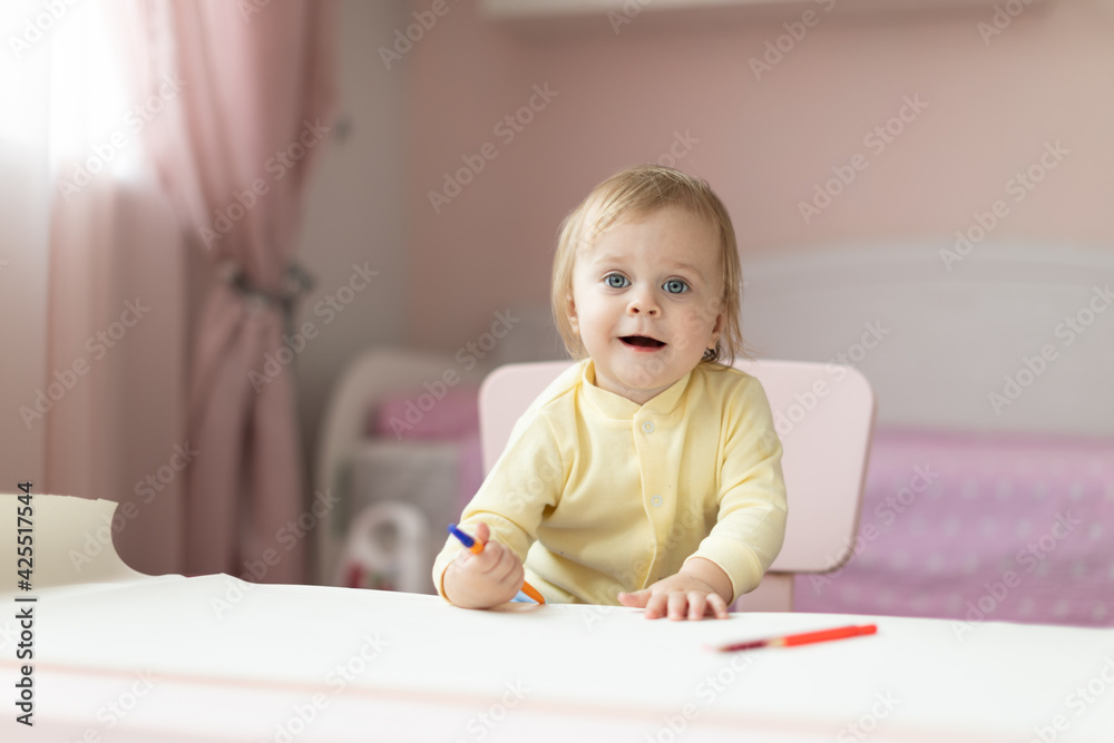 Baby draws at the table Baby draws at the table
