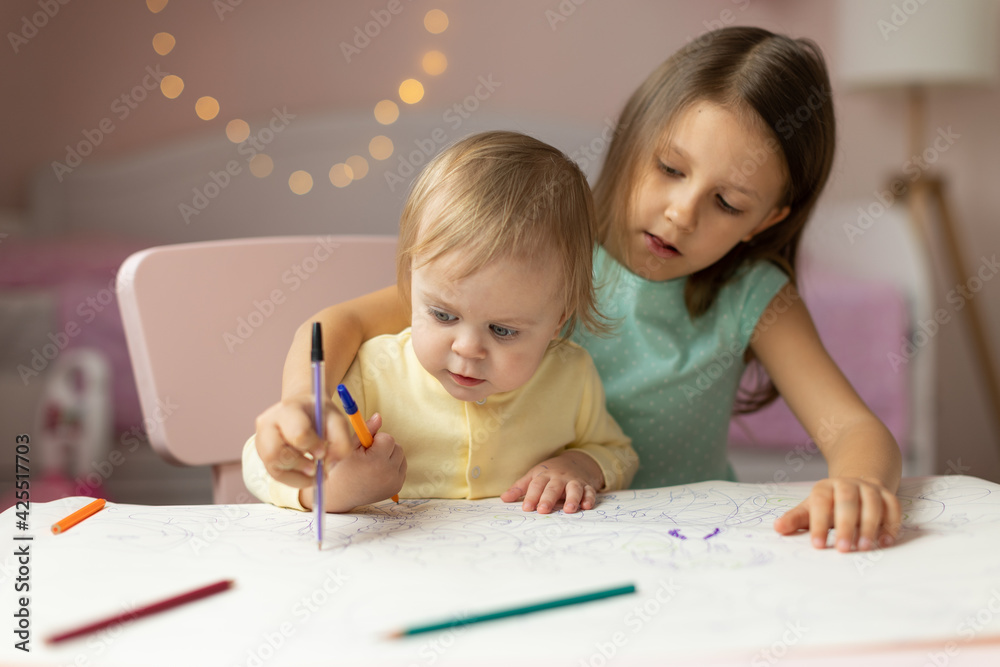two children draws at the table in the room, two children draws at the table in the room,