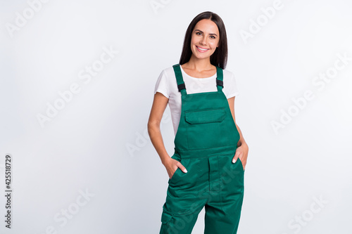 Photo of charming confident lady arms pockets shiny smile wear green overall isolated white color background photo