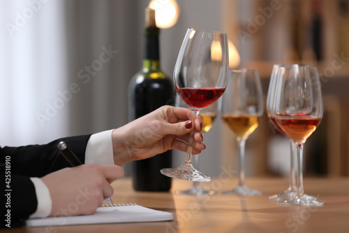 Sommelier tasting different sorts of wine at table indoors, closeup