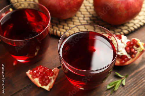 Pomegranate juice and fresh fruits on wooden table