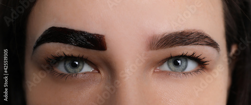 Woman during eyebrow tinting procedure, closeup view