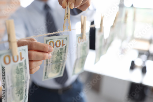 Man hanging american dollar bills on rope closeup